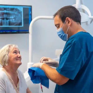 IMDEx - In a dental office, a dentist gives explanations to an elderly person