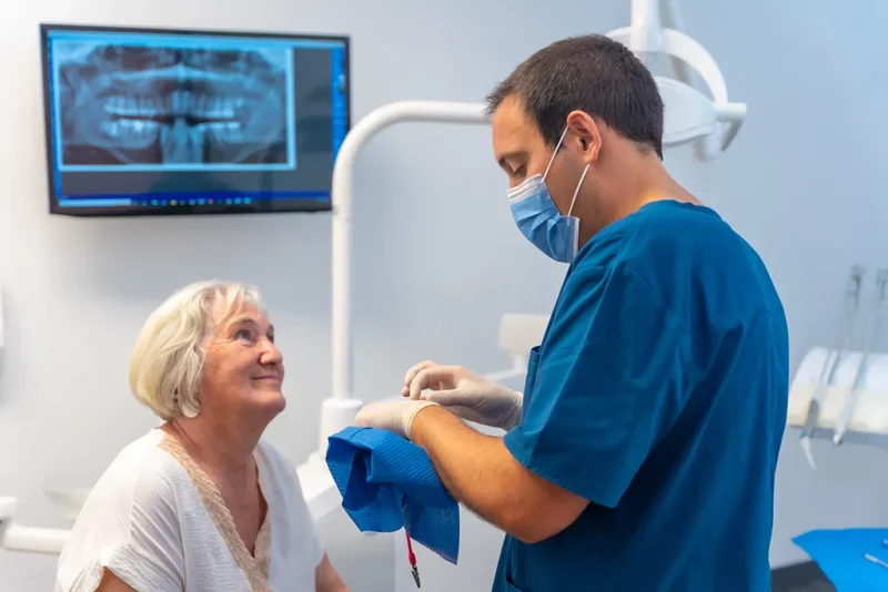 IMDEx - Dans un cabinet dentaire, un dentiste donne des explications à une personne âgée