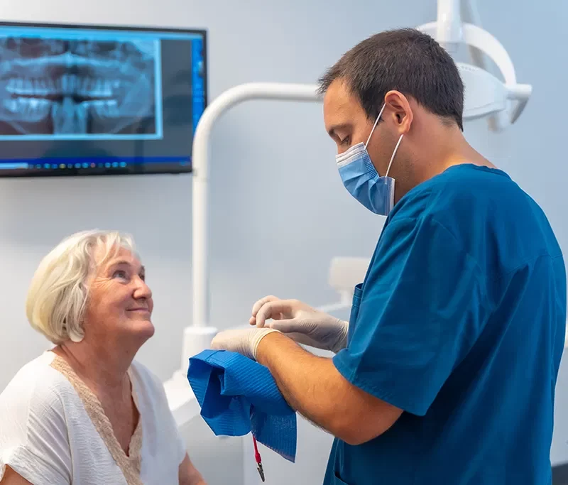 IMDEx - Dans un cabinet dentaire, un dentiste donne des explications à une personne âgée